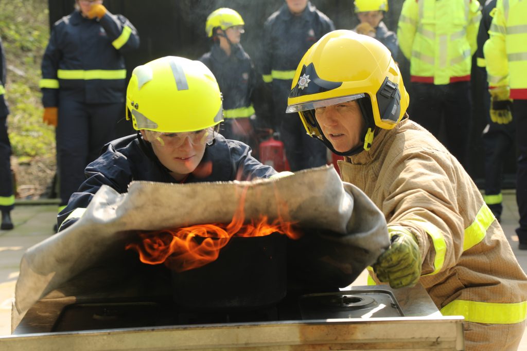 firefighter and cadet extinguishing a fire image